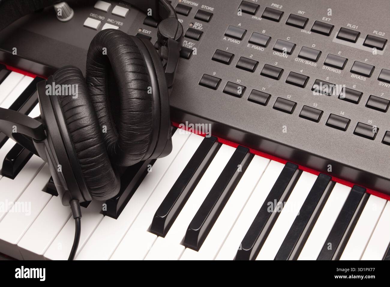 Hörkopfhörer, die auf der elektronischen Synthesizer-Tastatur liegen Stockfoto