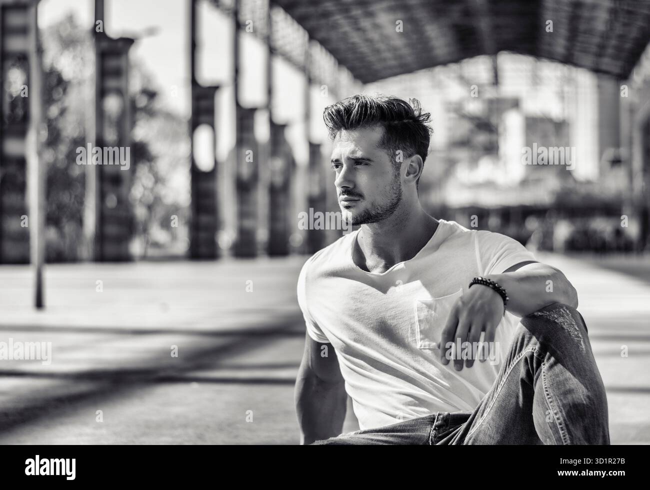 Mann in urbaner Umgebung unter großer Metallkonstruktion Stockfoto