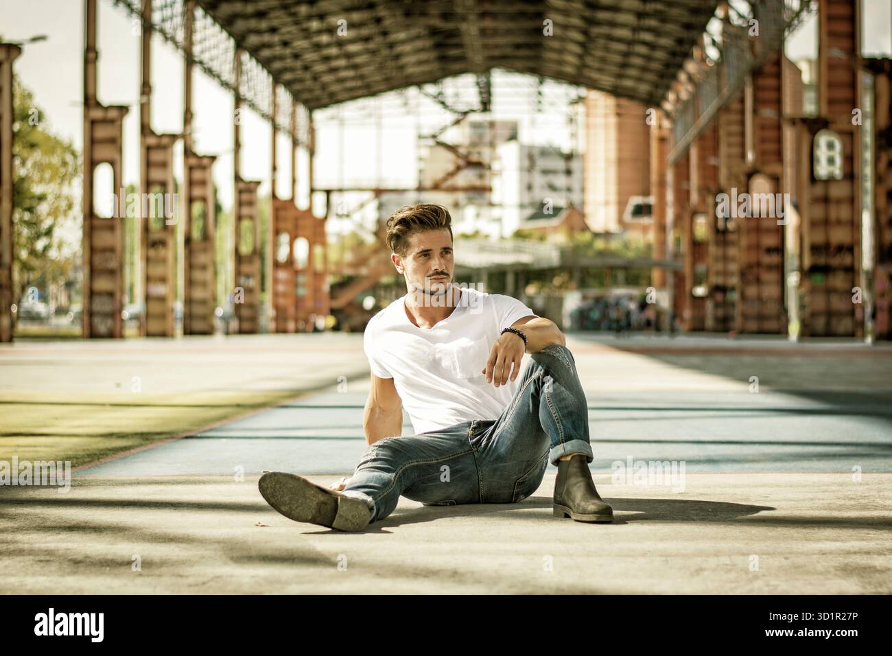 Mann in urbaner Umgebung unter großer Metallkonstruktion Stockfoto