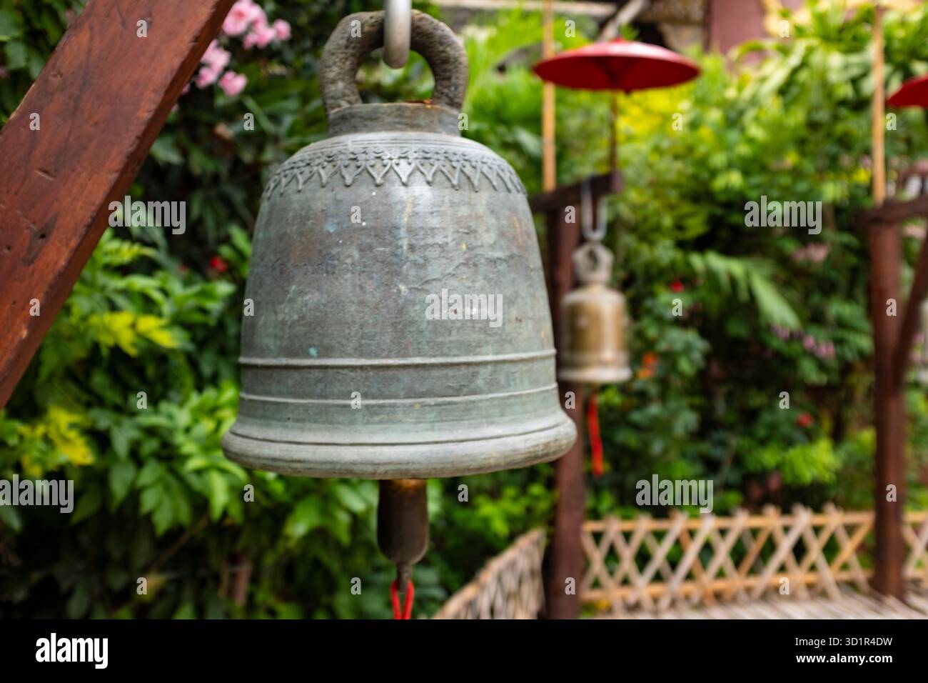 Alte Eisenglocke in einem traditionellen Garten in einem buddhistischen Tempel in Chiang Rai, Thailand Stockfoto