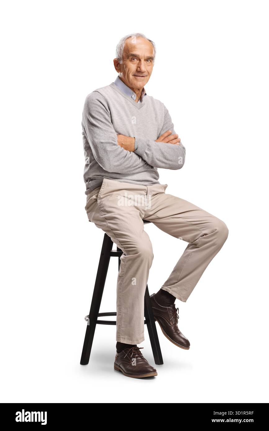 Lächelnder älterer Mann, der auf einem Stuhl sitzt, isoliert auf weißem Hintergrund Stockfoto