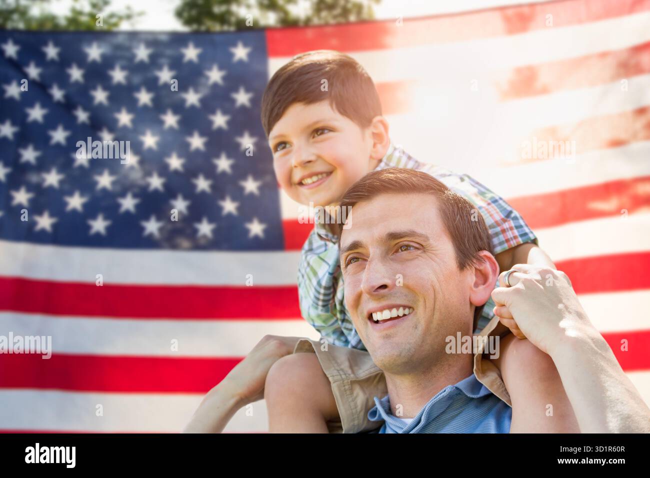Vater mit Sohn Huckepack Reiten vor der amerikanischen Flagge Stockfoto