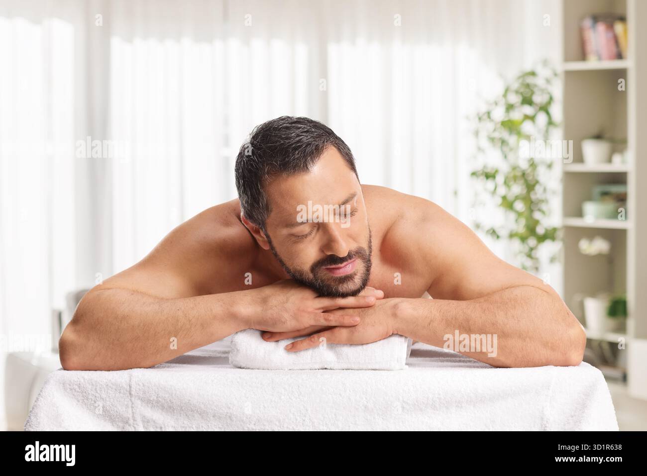 Mann, der sich nach einer Rückenmassage in einem Zimmer erholt Stockfoto