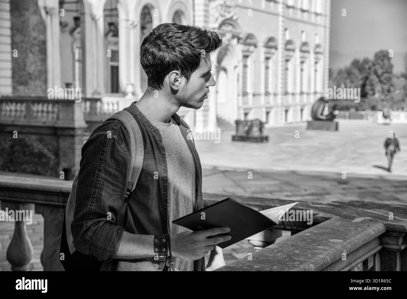 Junger Mann hält einen Leitfaden vor historischen Gebäude Stockfoto