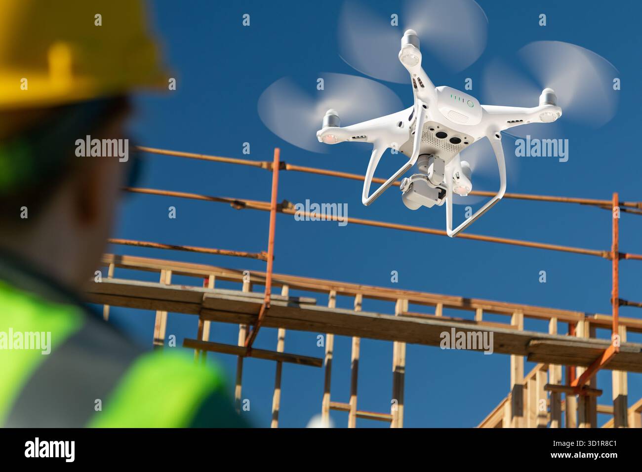 Weibliche Pilotin Fliegt Drohnen-Quadcopter Auf Baustelle Stockfoto