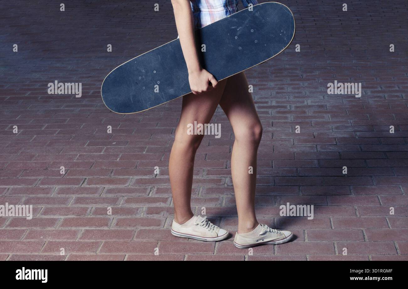 Seitenansicht von jungen Frauen mit Skateboard in warmen Farben im instagram-Stil Stockfoto