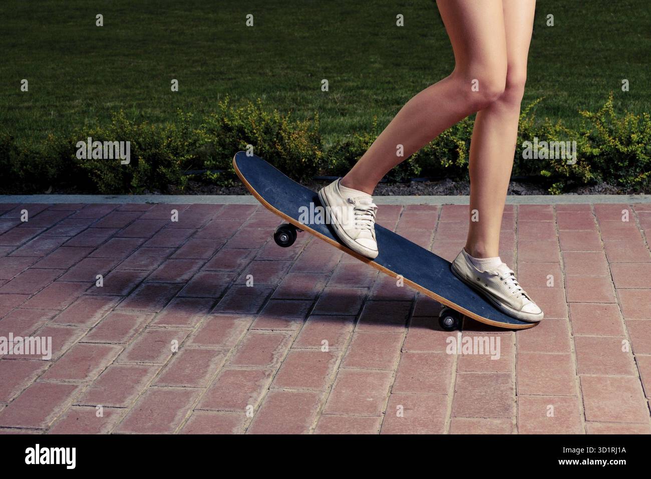 Junge Frauen, die einen Trick auf einem Skateboard-Bild machen, warme Farbe. Viel Platz für Text Stockfoto