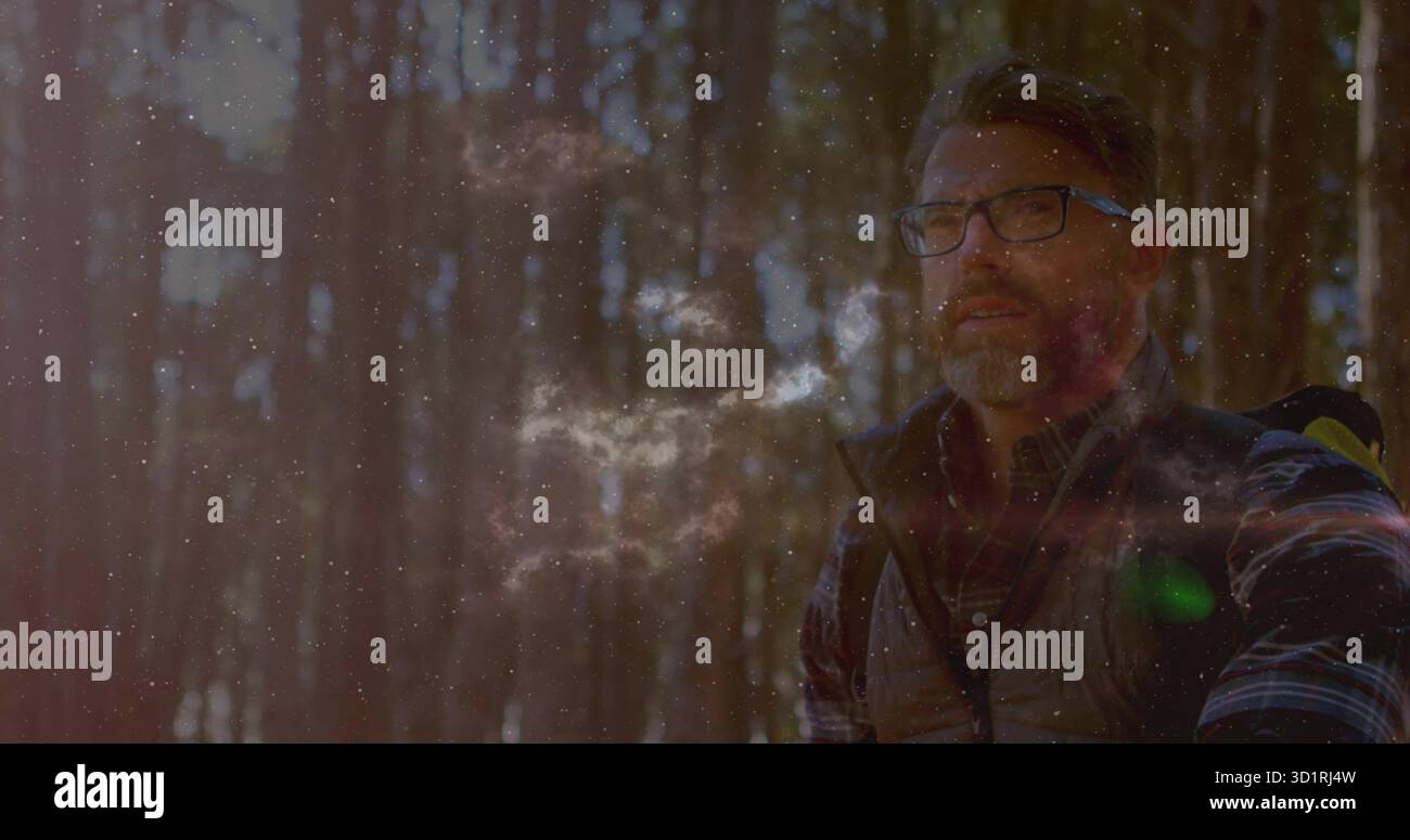 Männlicher Wanderer trägt Brille, Weste, atmet Dampf im Sonnenuntergang Wald, trägt Rucksack, Kopierraum Stockfoto