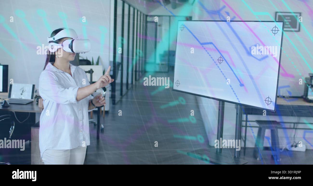 Asiatische Frau mit VR-Headset, die virtuelle Elemente im Großraumbüro, Kopierraum auswählt Stockfoto