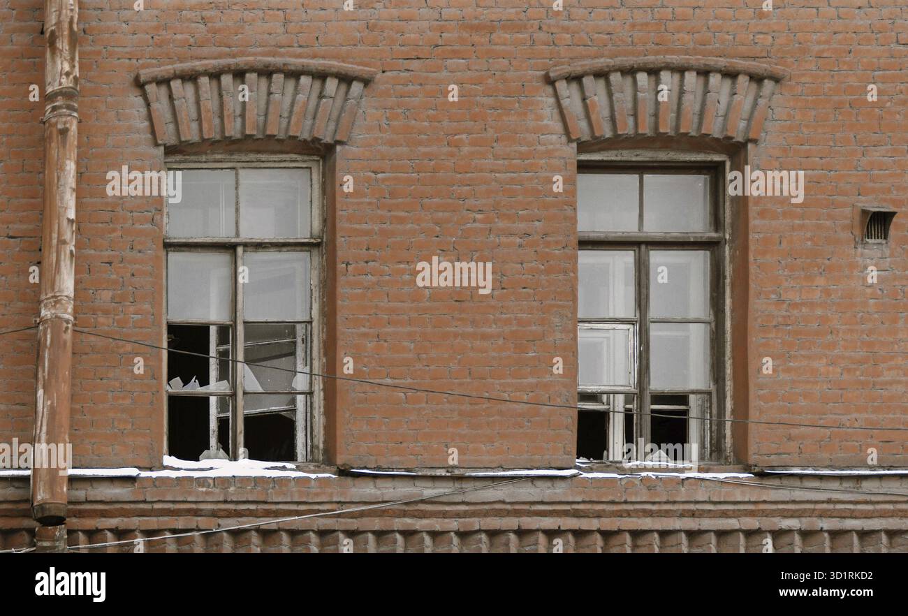 Zwei Glasfenster des alten Wohngebäudes in verlassenem Zustand Stockfoto