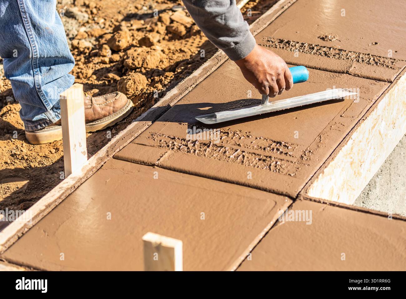 Bauarbeiter, Der Kelle Auf Nassem Zement Verwendet, Um Den Neuen Pool Zu Bedecken Stockfoto