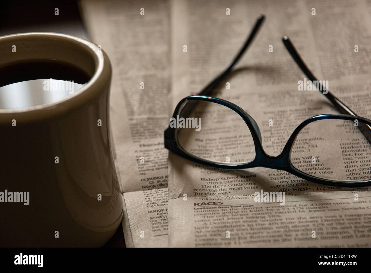 Lesen der Morgenzeitung mit Lesebrille und einer heißen Tasse Kaffee. Stockfoto