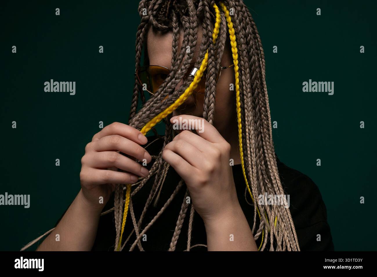 Frau mit Dreadlocks, die eine Brille hält Stockfoto