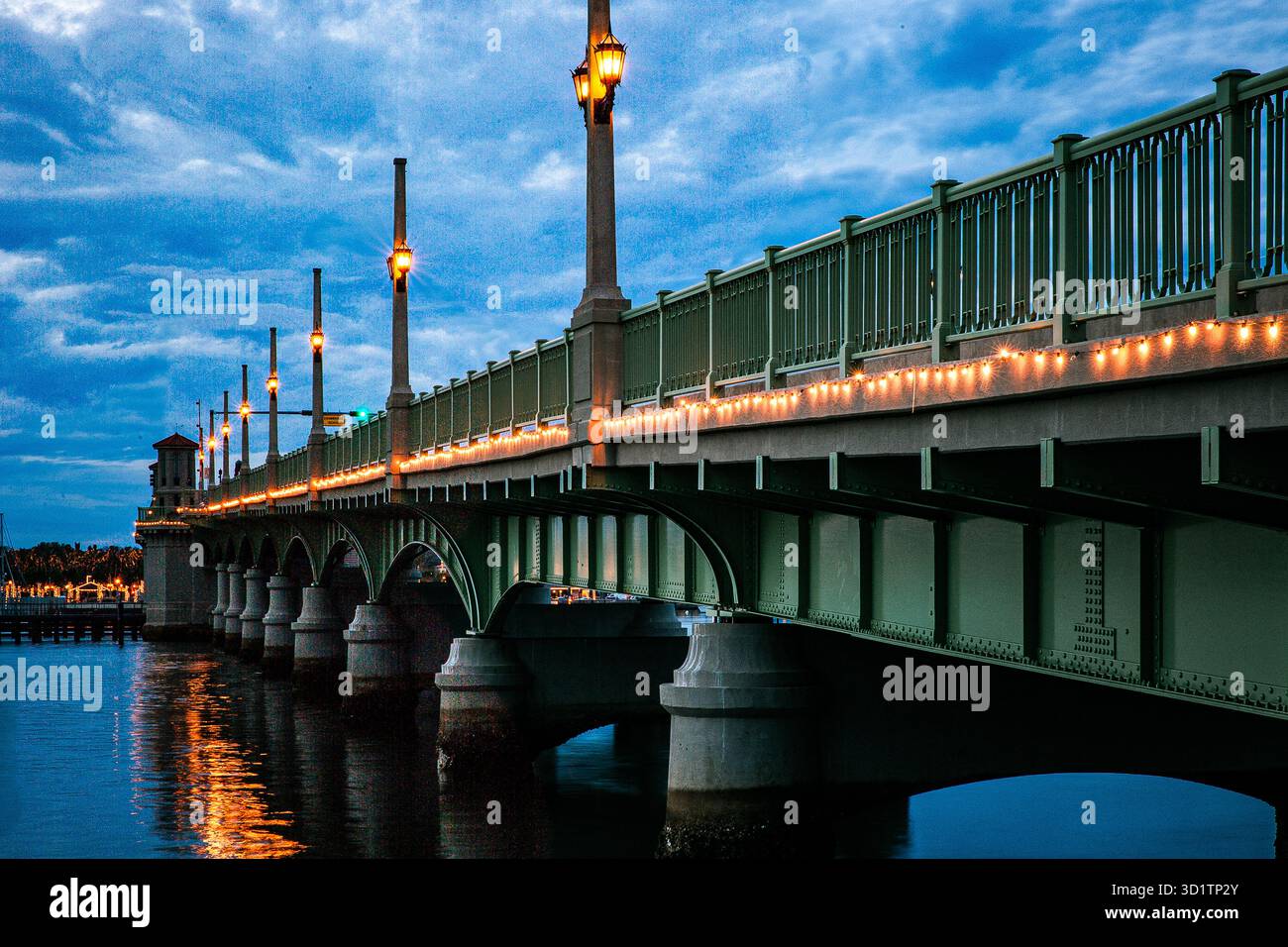Bridge of Lions in St. Augustine, Florida, beleuchtet mit leuchtenden Straßenlaternen und festlichen Lichtern in der Abenddämmerung. Die historische Zugbrücke Stockfoto