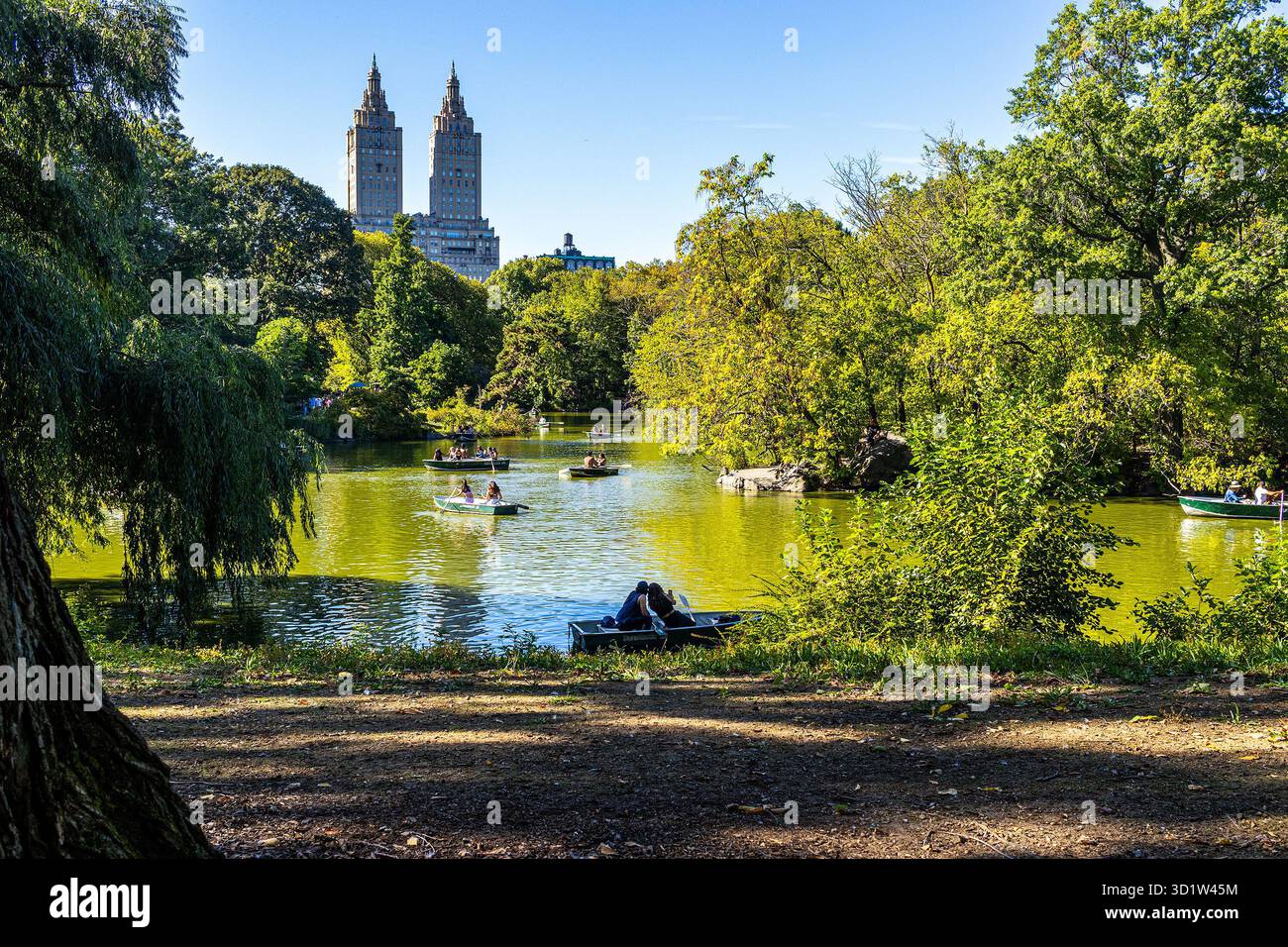 Im Central Park, Manhattan, New York City, Ruderboote im See, mit dem San Remo Gebäude im Hintergrund Stockfoto