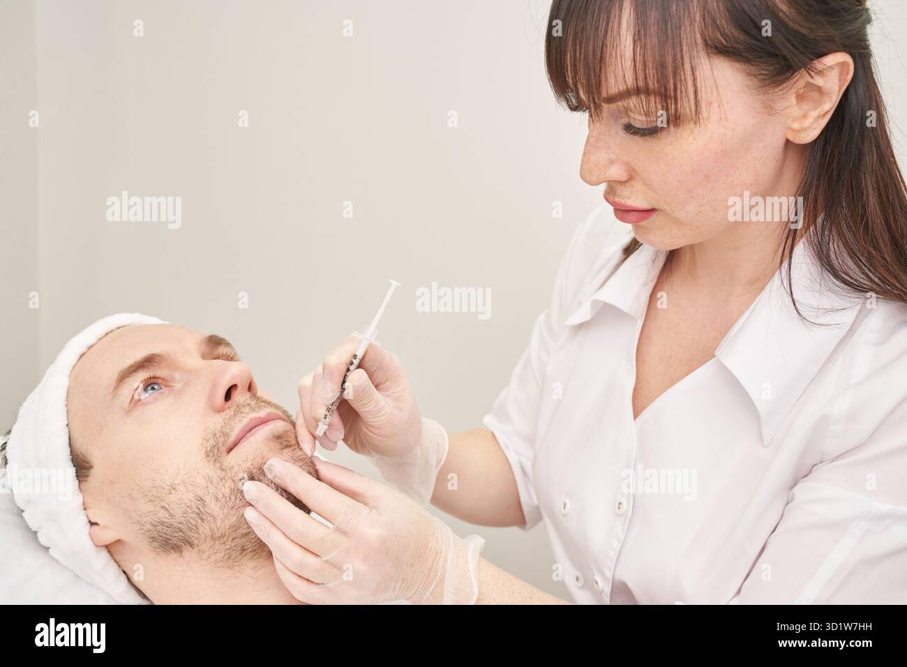 Injektion im Spa-Salon. Arzt Hände in Handschuhe. Nahaufnahme. Ziemlich männlicher Patient Stockfoto