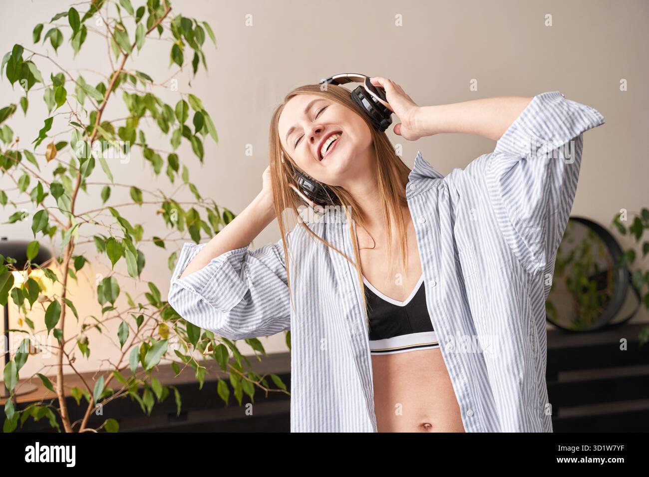 Junge Frau singt zu Hause. House Lyrics tanzen. Lustiges Lied. Unabhängiges Hochformat Stockfoto