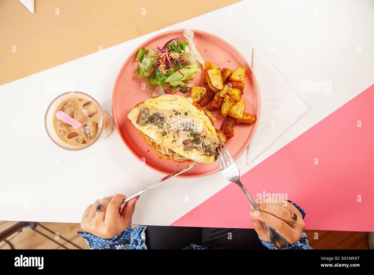 Arabische Frau genießt Brunch-Croissant-Sandwich mit Freunden in einem Restaurant. Stockfoto
