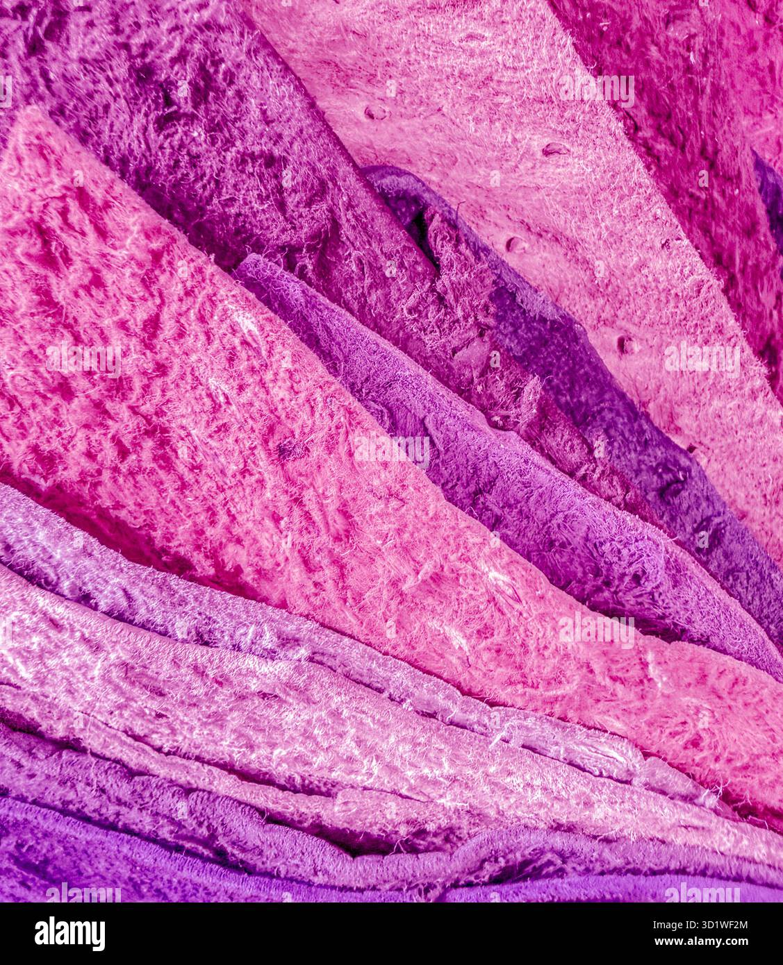 Muster aus Ledergewebe, die in Rosa-, Rose- und Magenta-Tönen angeordnet sind. Das Makrobild vergleicht Farbtöne mit rauen Texturen. Stockfoto