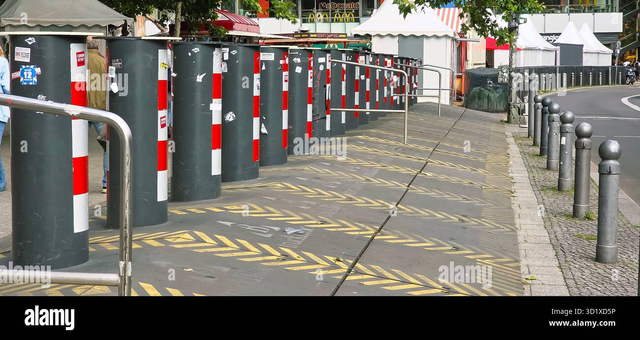 Berlin, Deutschland - 11. Juni 2025: Blick auf die urbane Straße mit Pollern und Fußgängerwegen in pulsierendem Stadtumfeld. - Smartphone-aufgenommenes Stockfoto