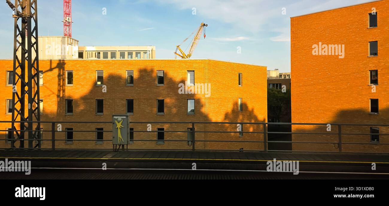 Berlin, Deutschland - 13. Juni 2025: Urbane Bauszene mit Ziegelbauten und einem Kran gegen den Himmel. - Smartphone-aufgenommenes Stockfoto