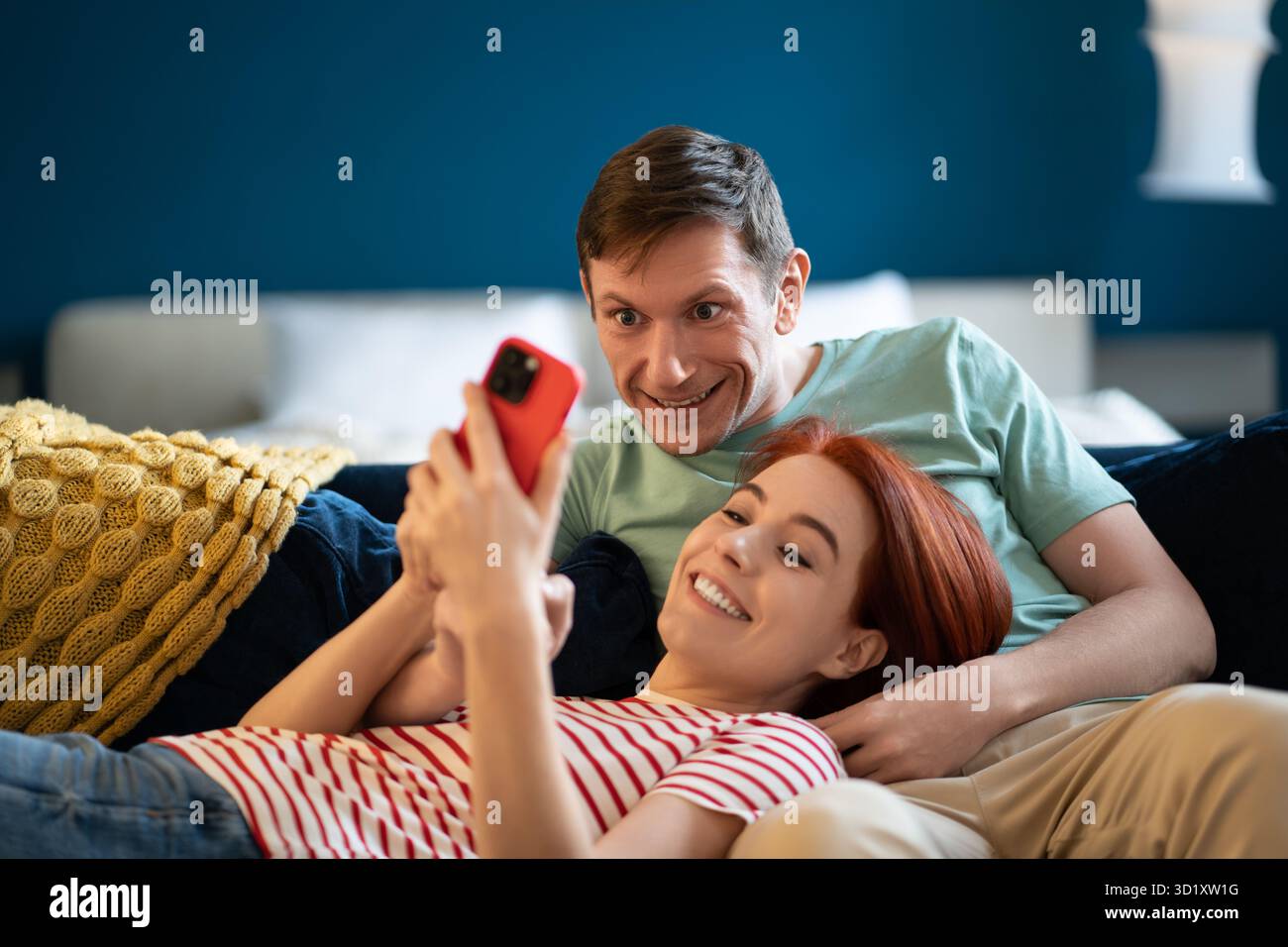 Mann und Frau, die Videos auf dem Smartphone ansehen. Ruhe, Entspannung, gute angenehme Qualität, komfortabler Freizeitvertreib Stockfoto