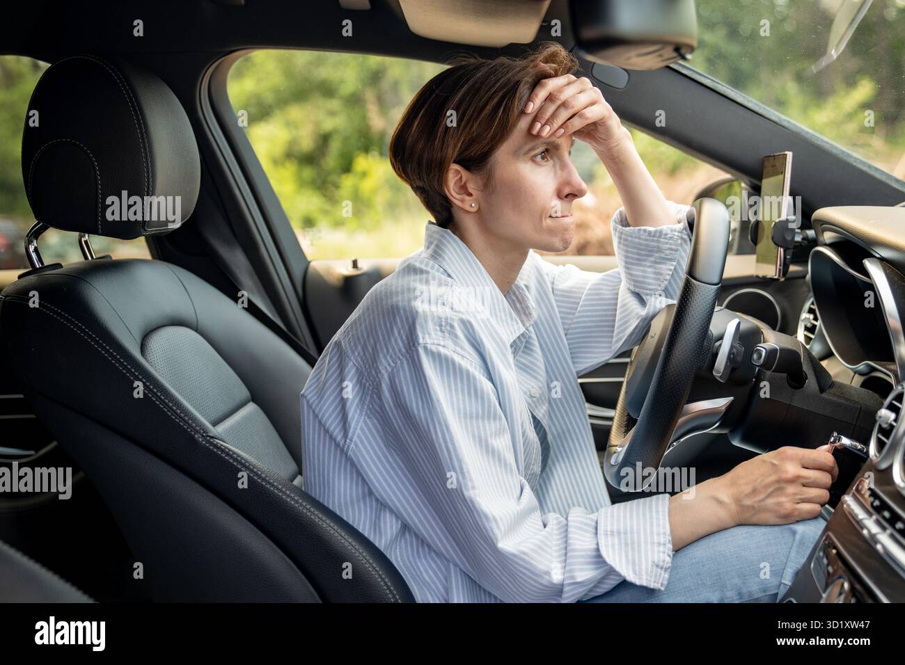Gestresste Frau mittleren Alters, die Auto fährt und Probleme mit der Voraussicht hat. Stockfoto