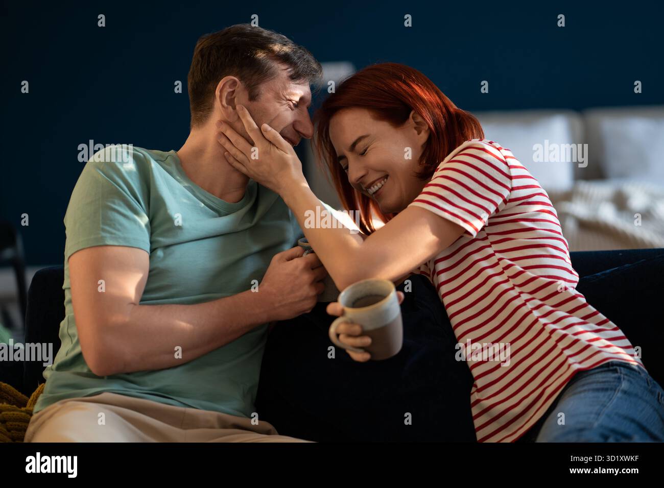 Positives Paar mittleren Alters, das sich scherzhaft aneinander lacht. Emotionale Verbundenheit in der Familie. Stockfoto