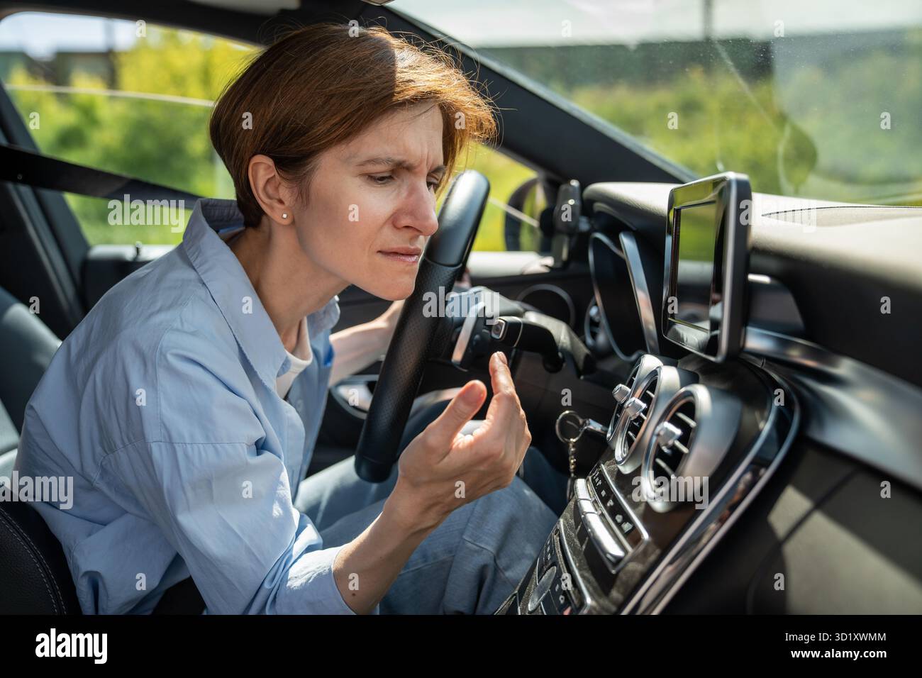 Schlechter Geruch von der Klimaanlage im Auto. Die Fahrerin hat nach dem Einschalten der Klimaanlage einen unangenehmen Geruch Stockfoto