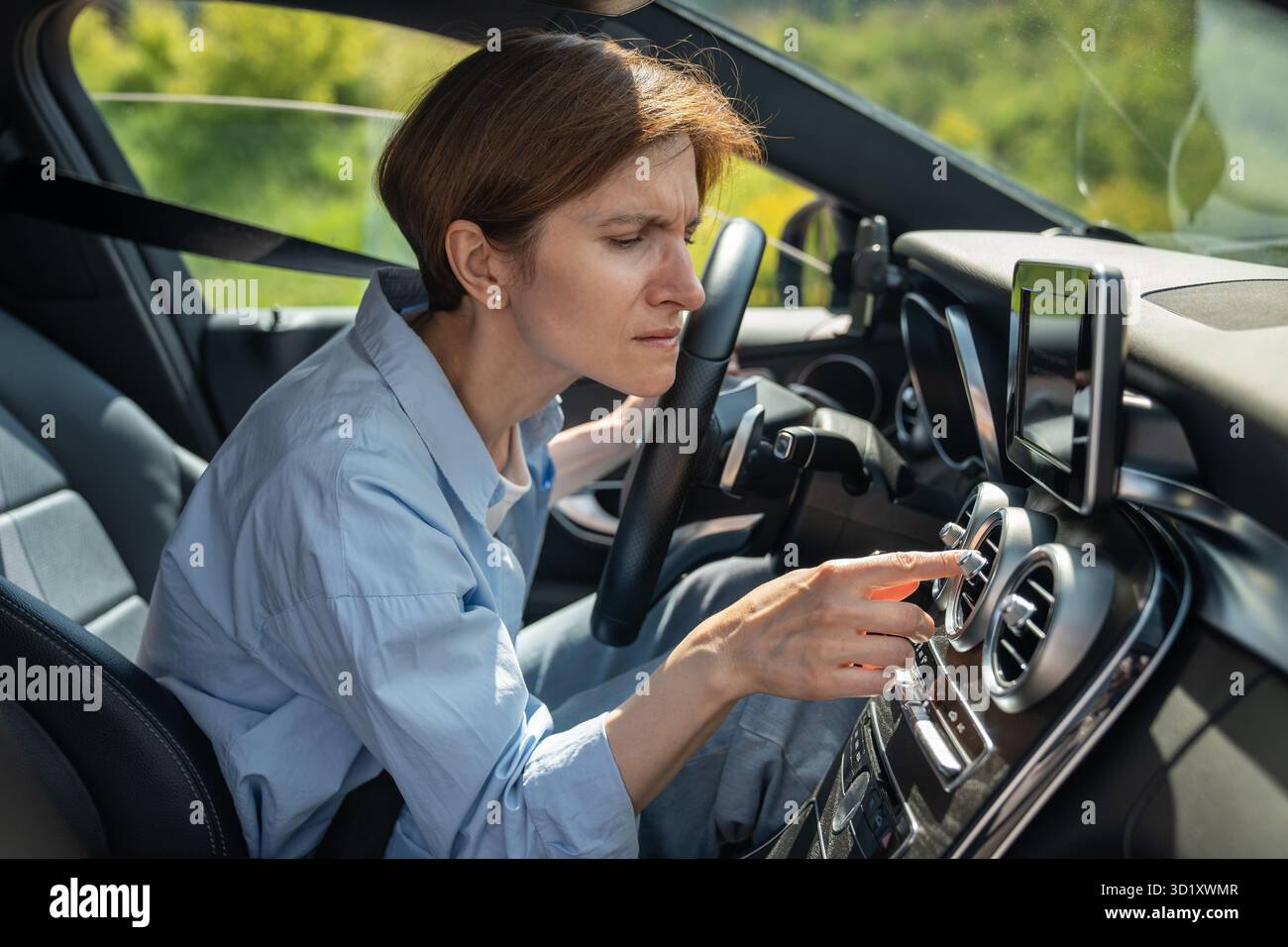 Schlechter Geruch von der Klimaanlage im Auto. Die Fahrerin hat nach dem Einschalten der Klimaanlage einen unangenehmen Geruch Stockfoto