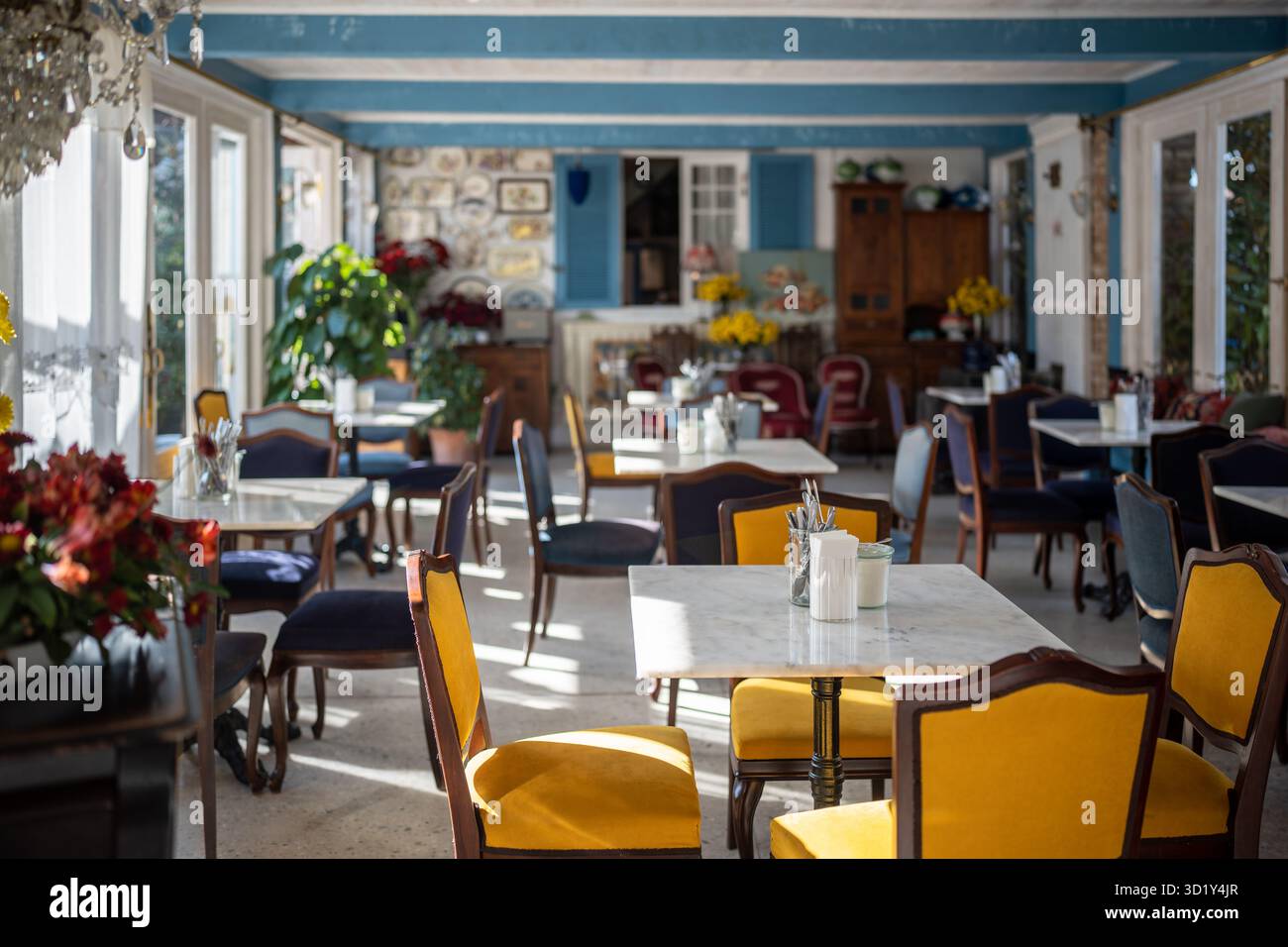 Gemütliches Restaurant mit luxuriöser, komfortabler Atmosphäre, eleganten Sesseln, raffinierten Kronleuchtern und Pflanzen Stockfoto