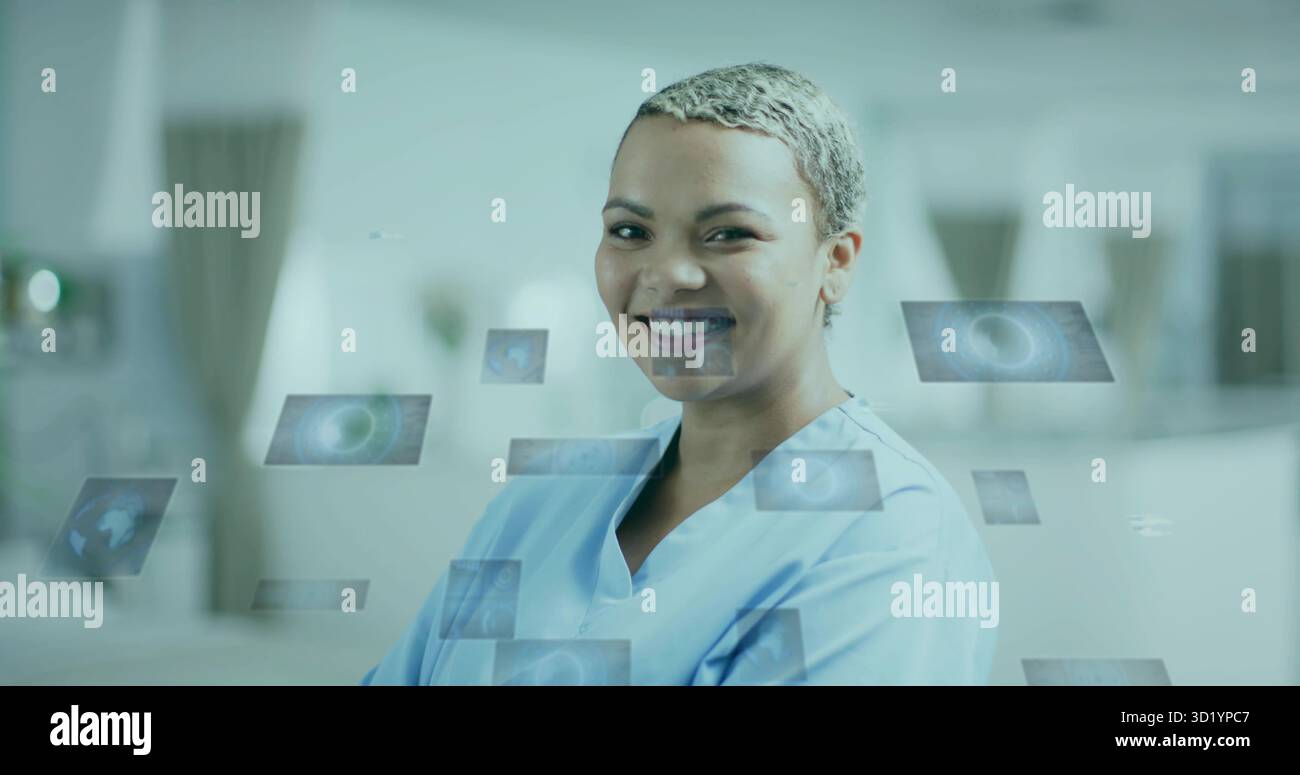 Stehende Ärztin mit Scrubs lächelnd mit schwebenden digitalen Panels in Klinik mit Raumgrafik Stockfoto