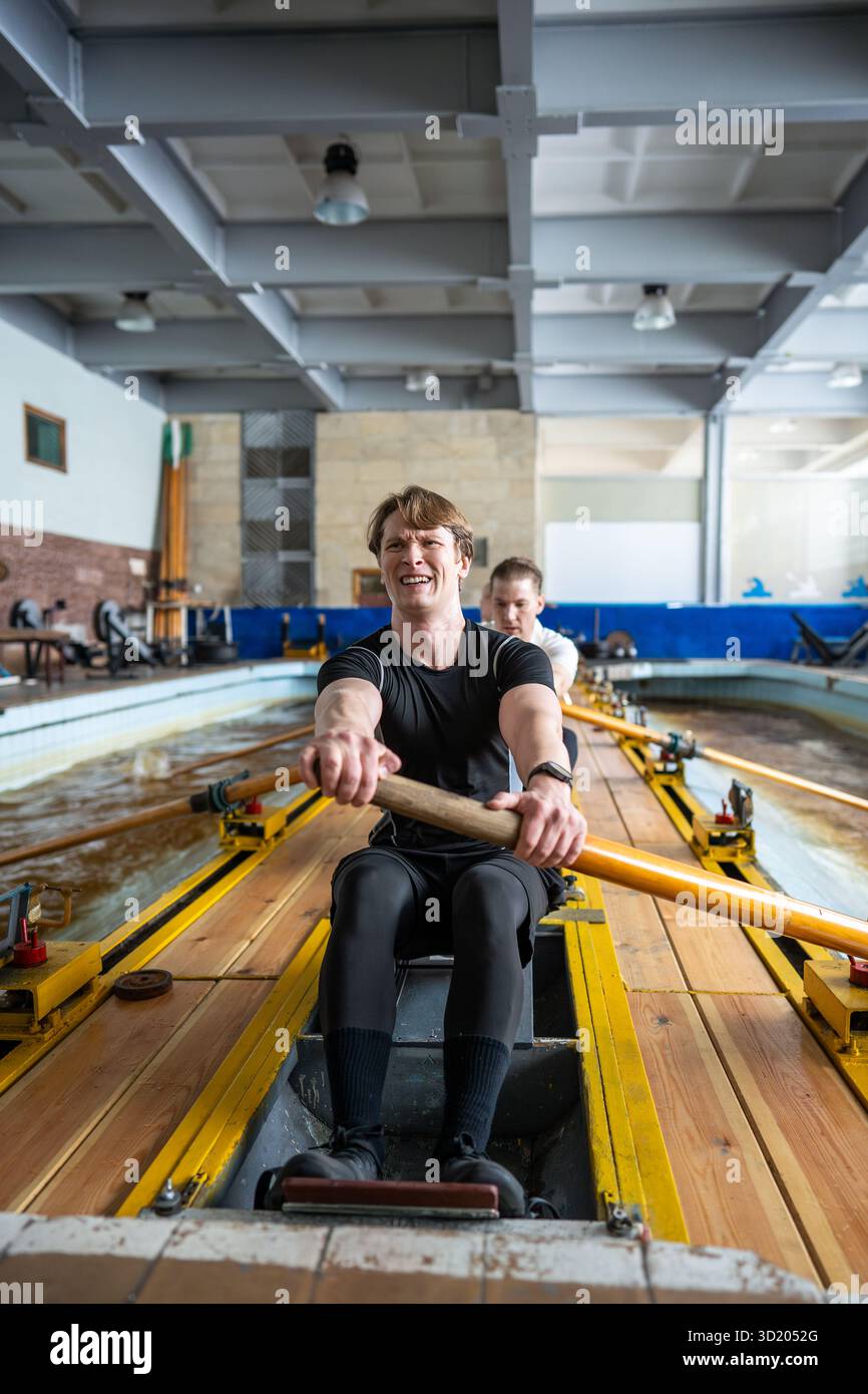 Die engagierte männliche Rudermannschaft übt Synchronisation, Paddelvorbereitung, Sportaktivitäten und Hobby Stockfoto