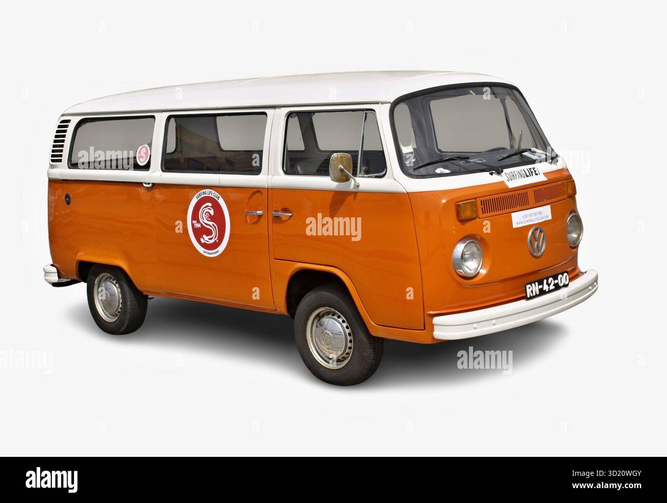 Der orange-weiße Volkswagen Kombi T2 ist geparkt und zeigt Aufkleber zum Surfen Stockfoto