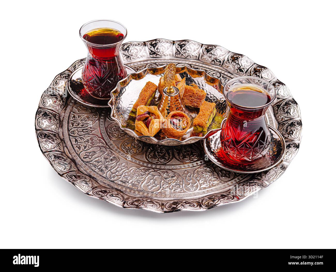 Traditioneller türkischer Tee und Süßigkeiten werden auf einem kunstvollen Metalltablett in nahöstlicher Umgebung serviert Stockfoto