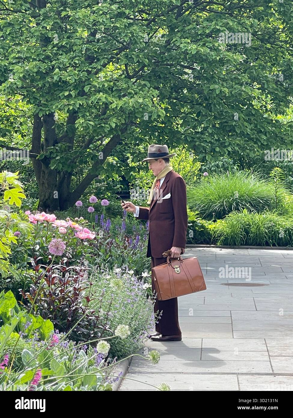 Frühling im Central Park: Ein Fotograf arbeitet zwischen den Blüten - Smartphone-aufgenommenes Stockfoto