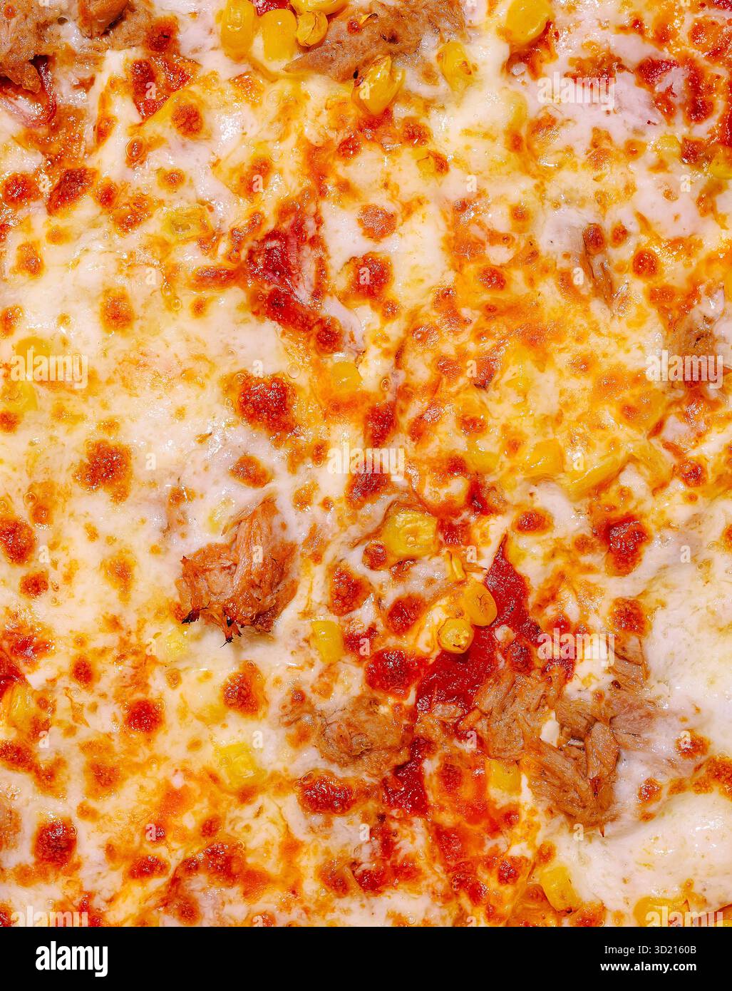 Köstliche Pizza mit Mais und Fleisch, frisch aus dem Ofen in einer gemütlichen Küche serviert Stockfoto