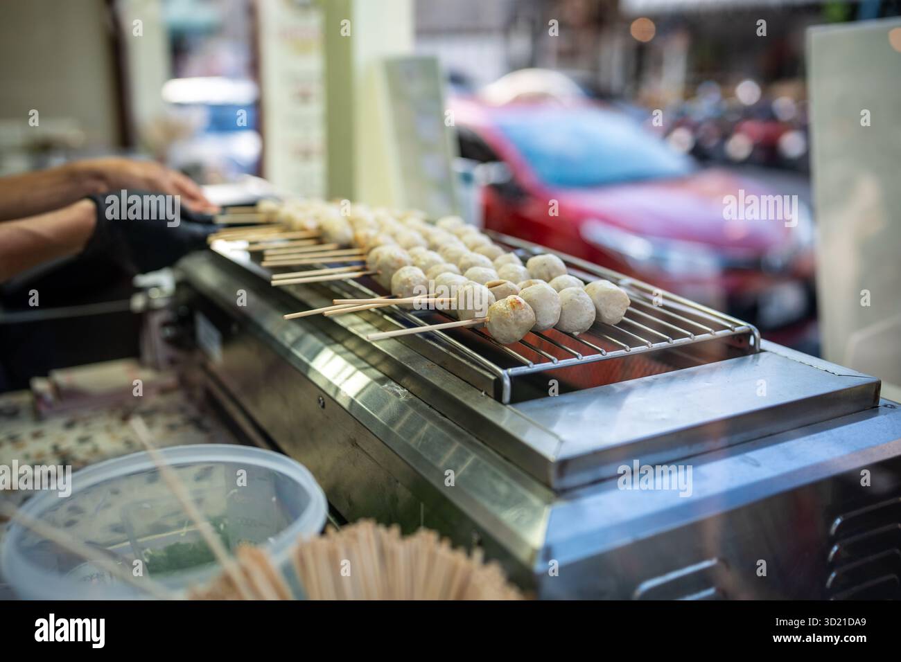 Kochen Sie Flips Schweinefleisch Satay Sticks und gedämpfte Fleischbällchen am Straßencafé in thailand Stockfoto