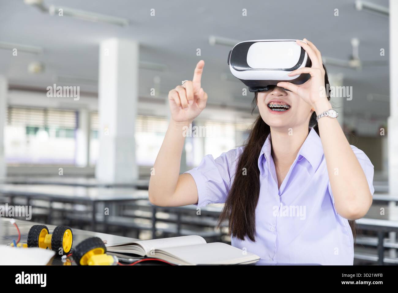 Kluge Schüler Teenager in einheitlichem LERNSTAMM mit VR-Headset-Technologie Zukunftslerngerät auf dem modernen Schulcampus in Indoor. Stockfoto