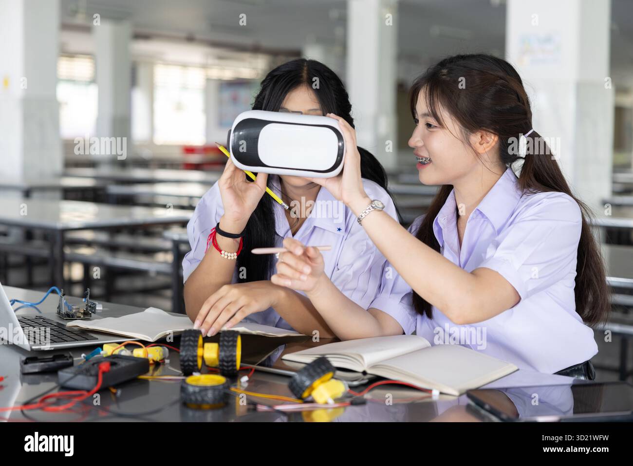 Kluge Schüler Teenager in einheitlichem LERNSTAMM mit VR-Headset-Technologie Zukunftslerngerät auf dem modernen Schulcampus in Indoor. Stockfoto