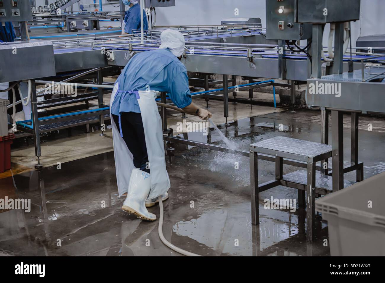 Ruhiges Werk, nur wenige Werksarbeiter reinigen die Produktionslinie Förderband bereiten sich darauf vor, die Betriebsstätte für Lebensmittel zu schließen Stockfoto