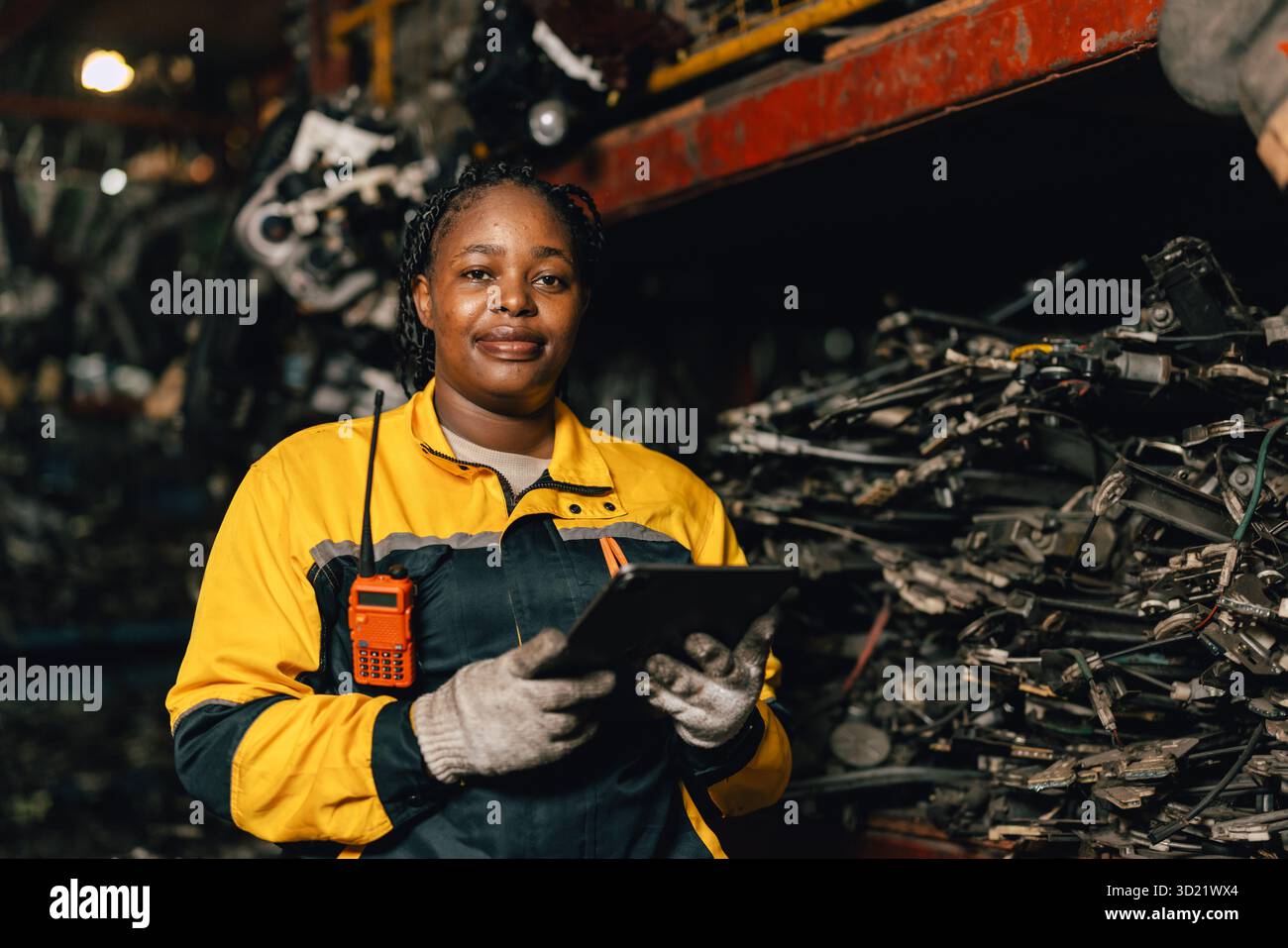 Glückliche schwarze afrikanische Ingenieurinnen arbeiten gerne in alten Lagerlagern für gebrauchte Metallmaschinenteile. Stockfoto