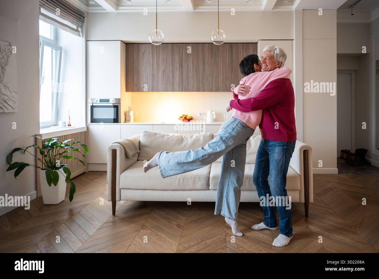 Überglückte reife Frau, die in Ehemann rennt, Armumarmung. Seniorenpaarfeier, glückliches Familientreffen Stockfoto