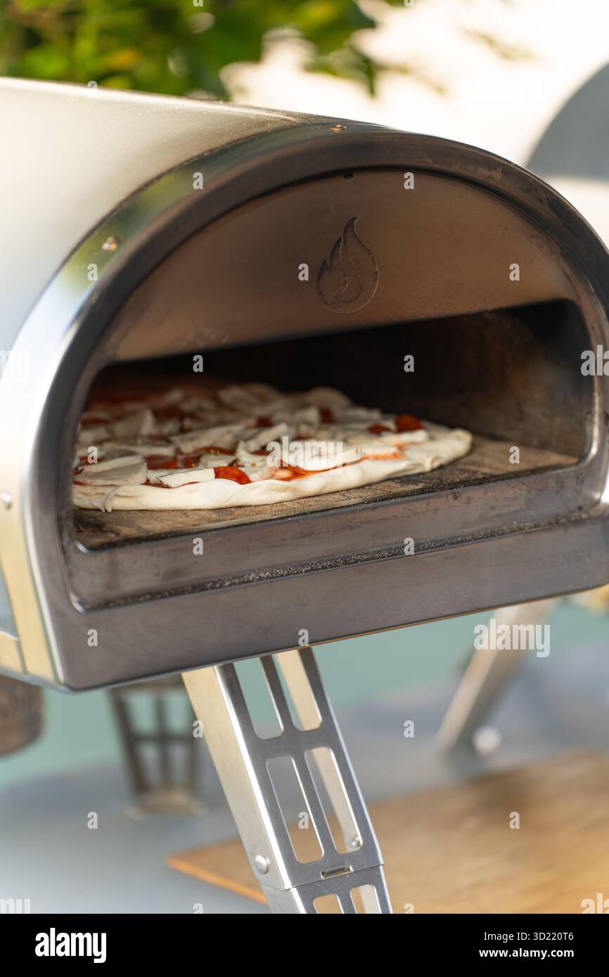 Pizza im Ofen im Freien mit geschmolzenem Käse Stockfoto