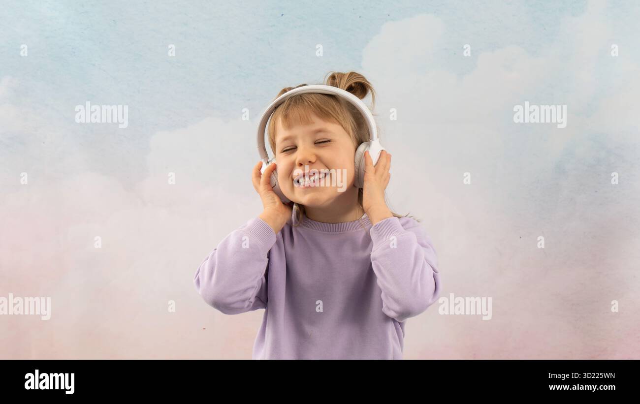 Das junge Schulmädchen genießt es, mit einem Lächeln Lieblingsmusik zu hören Stockfoto