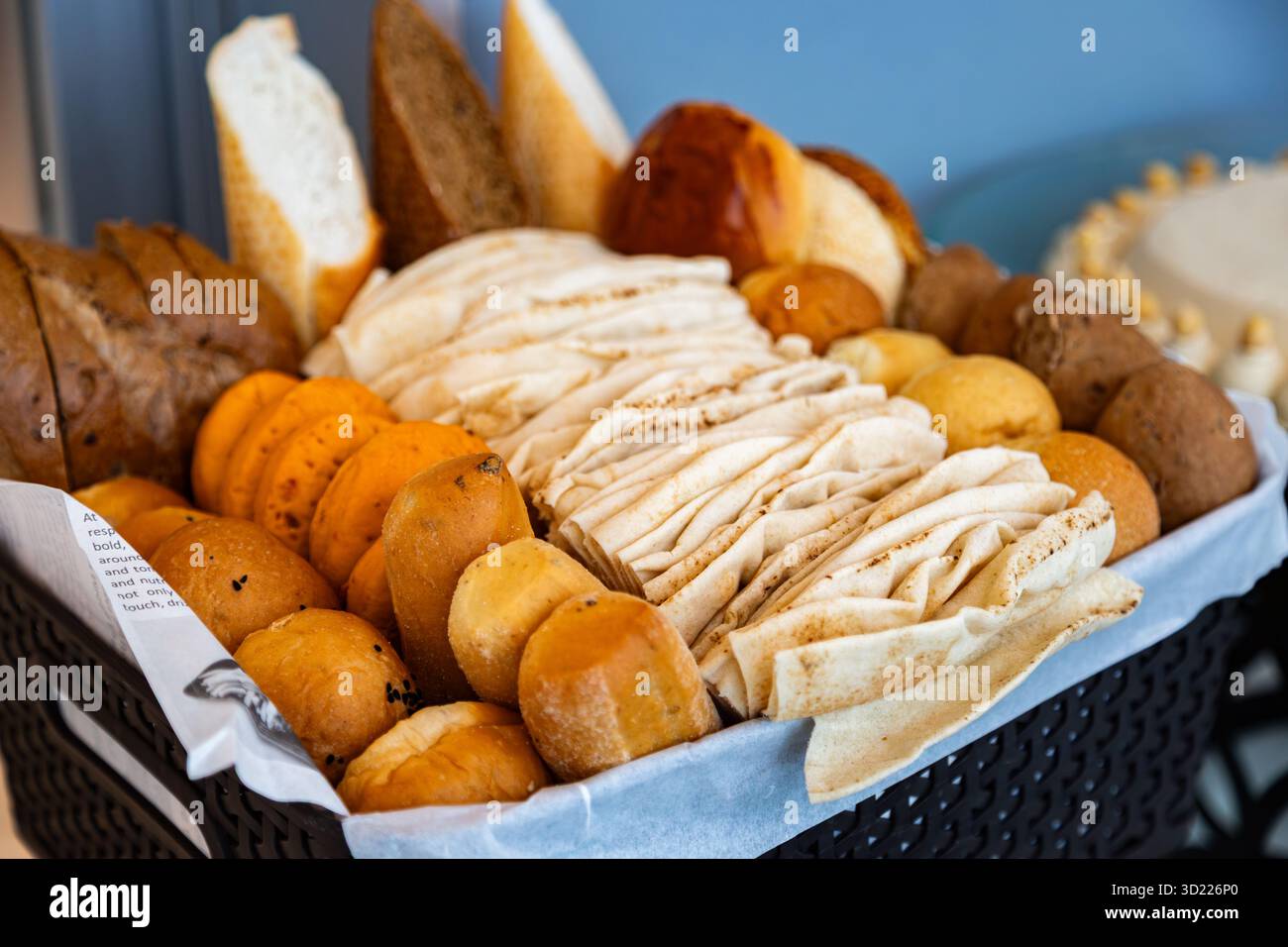 Auswahl an frisch gebackenem Brot, Mittagsbrötchen und Brezeln in einem Kunststoff-Rattan-Korb als Vorspeise oder Vorspeise. Stockfoto