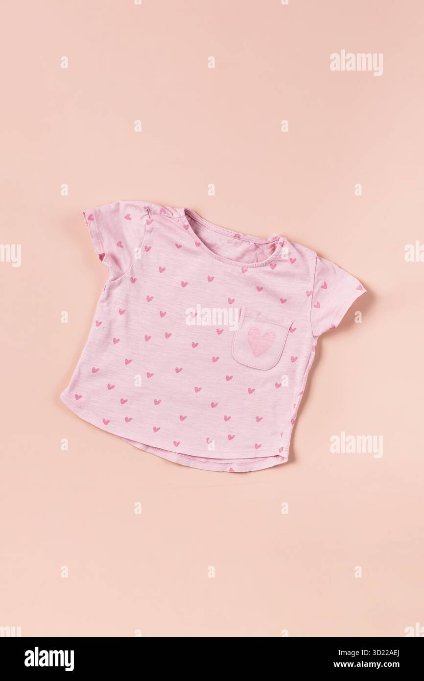 Pinkes Kinder-T-Shirt mit Herz auf beigem Hintergrund. Mode für Mädchen. Stockfoto