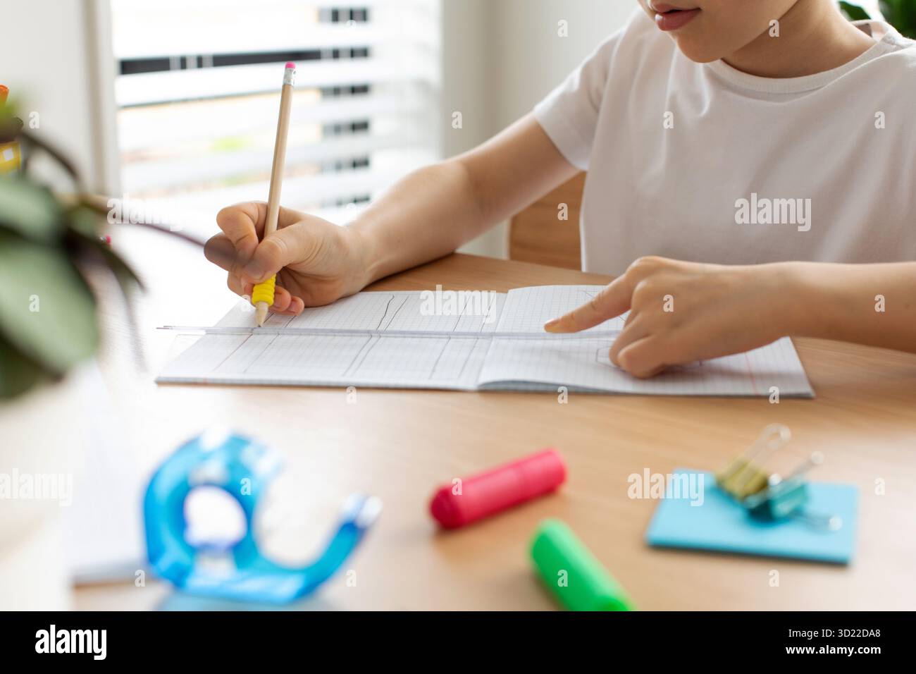 Ein süßer Junge zeichnet mit Lineal und Bleistift. Hausunterricht. Geometrie und Zeichnung. Stockfoto