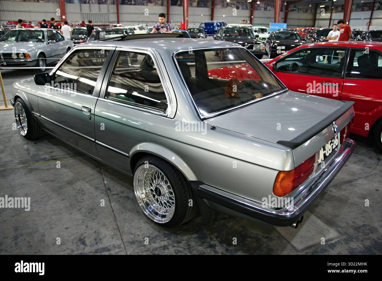 Individueller BMW E30 in Silber mit glänzenden Felgen in der Ausstellungshalle Stockfoto