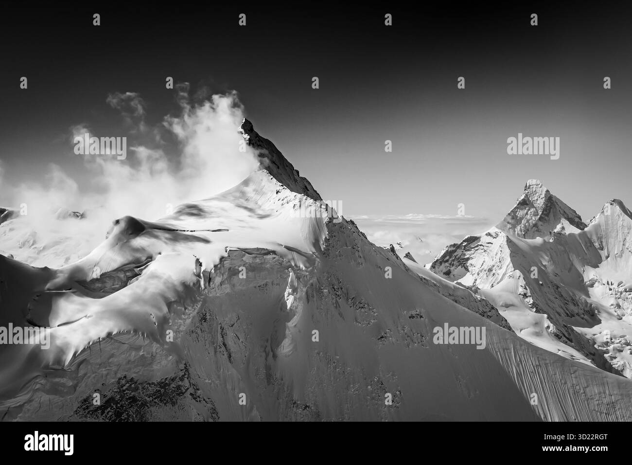 Der Zinalrothorn ist in seiner schönen Form einer der abgelegeneren alpinen Titanen über Zermatt. Die Wolken am frühen Morgen halten es teilweise verborgen. Stockfoto